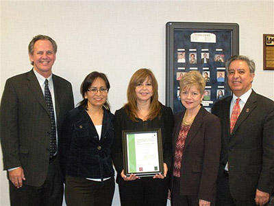 Olga Chapa is presented with a doctoral research award from Bea Ramirez