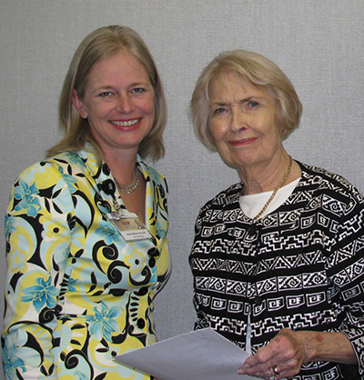 Julia Martin, right, holds a signed agreement with Kathryn Tart to establish the Dr. Thomas L. Martin Scholarship for graduate nursing students.