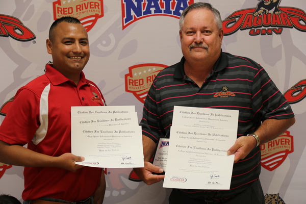 George Rodriguez and Paul Ebner show some of the nine awards received at the College Sports Information Directors of America Summer Convention for marketing pieces